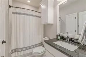 a bathroom with a granite countertop sink toilet and shower