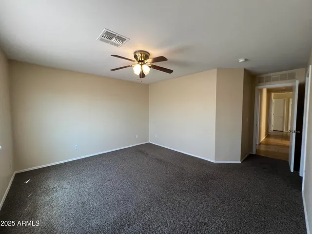 an empty room with a ceiling fan and a window