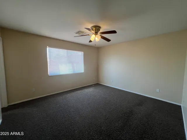 an empty room with a window and a fan