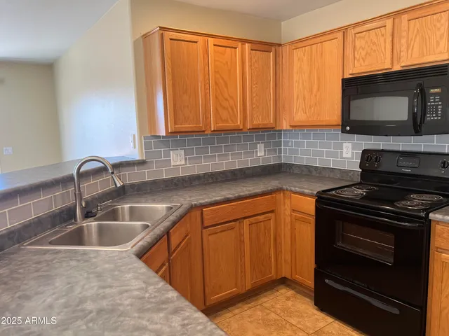 a kitchen with granite countertop a sink stainless steel appliances and cabinets
