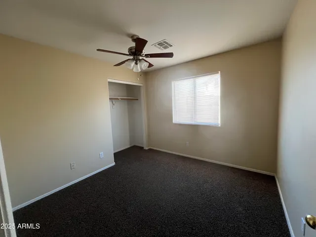 an empty room with a window and a fan