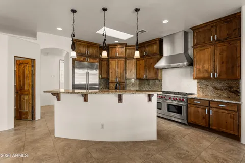 a large kitchen with stainless steel appliances granite countertop a stove a sink and a refrigerator