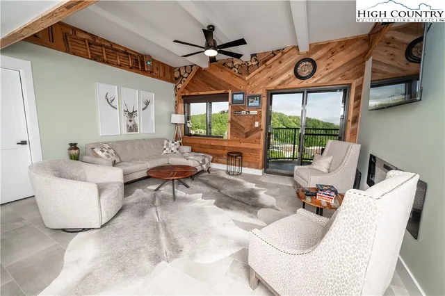 a living room with furniture a large window and a chandelier