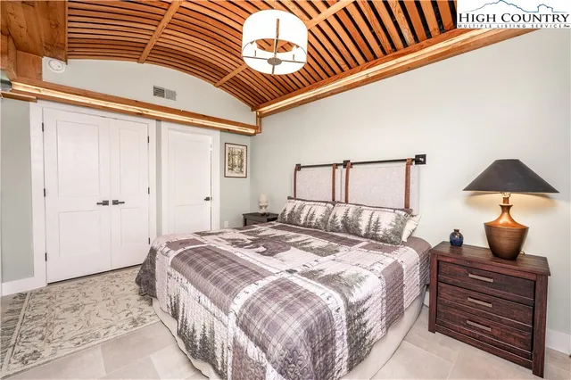 a bedroom with a bed and a lamp on the dresser