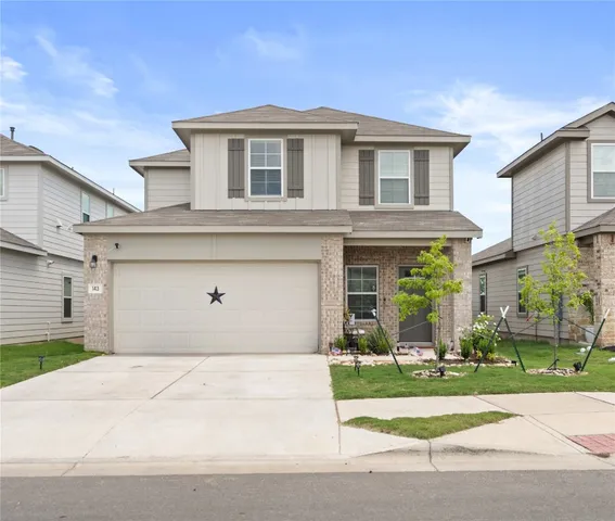 a front view of a house with a yard and a garage