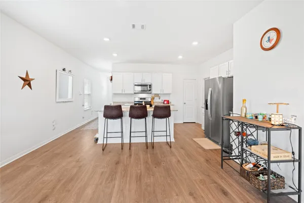 a view of kitchen with stainless steel appliances a refrigerator and wooden floor