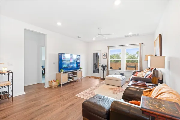 a living room with furniture flat screen tv and a large window