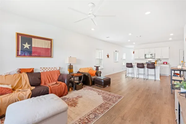 a living room with furniture wooden floor and a kitchen view
