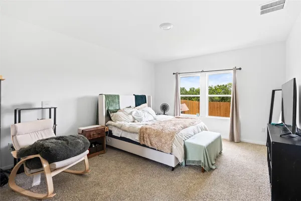 a bedroom with a bed and a view of living room