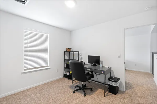 a view of a workspace with furniture and a window