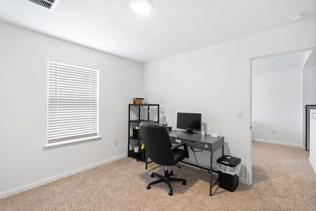 a view of a workspace with furniture and a window