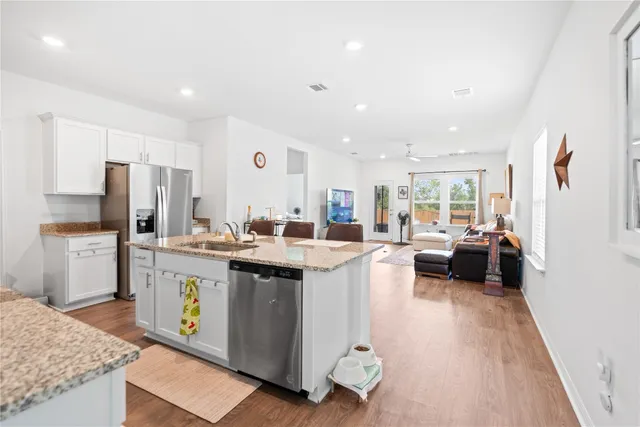 a kitchen with stainless steel appliances granite countertop a sink stove and refrigerator
