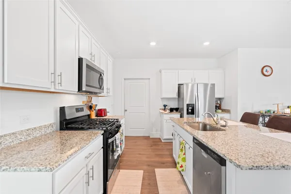 a kitchen with stainless steel appliances granite countertop a sink stove and refrigerator