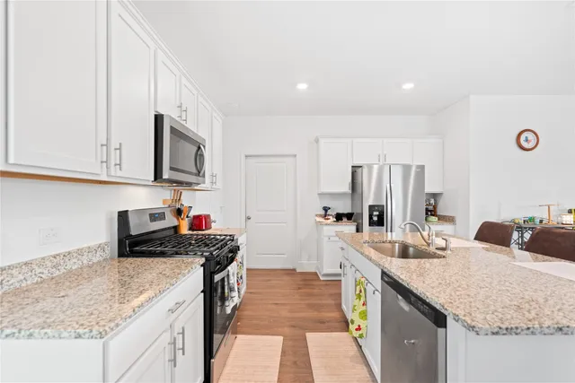 a kitchen with stainless steel appliances granite countertop a sink stove and refrigerator