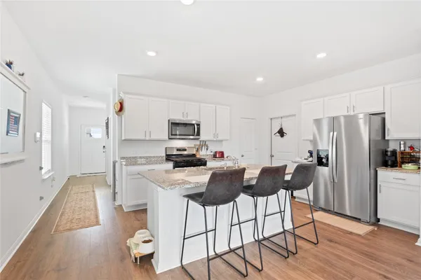 a kitchen with stainless steel appliances a refrigerator stove microwave and cabinets