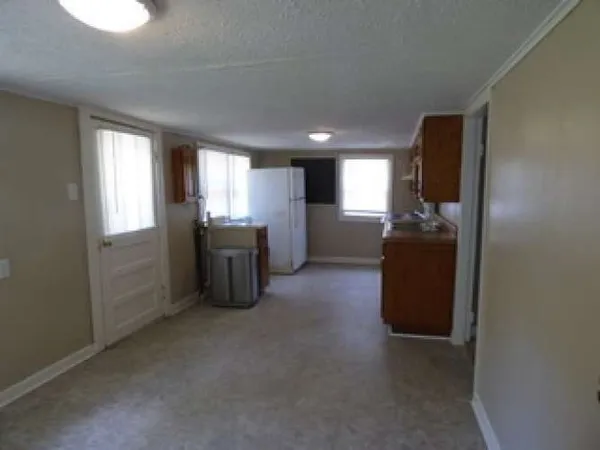 a view of a kitchen with refrigerator and windows