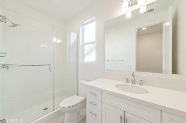 a bathroom with a sink toilet vanity and shower