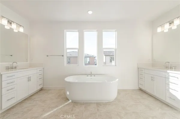 a spacious bathroom with a double vanity sink a mirror and a bathtub