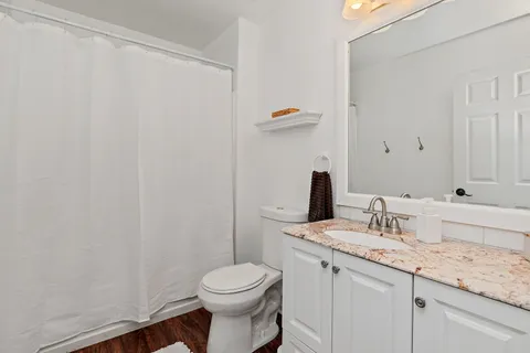 a bathroom with a granite countertop sink and a mirror