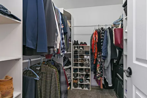 a view of walk in closet with clothes and shoes