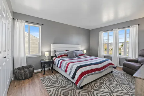 a bedroom with a bed a couch and a window