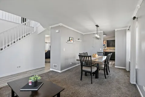a view of a dining room with furniture and chandelier