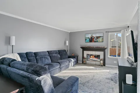 a living room with furniture a flat screen tv and a fireplace