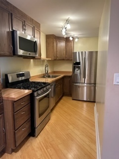8232 Niles Center Road, Unit 404 Skokie, IL 60077 - Photo 2 of 5 a kitchen with stainless steel appliances granite countertop a stove a refrigerator and a microwave