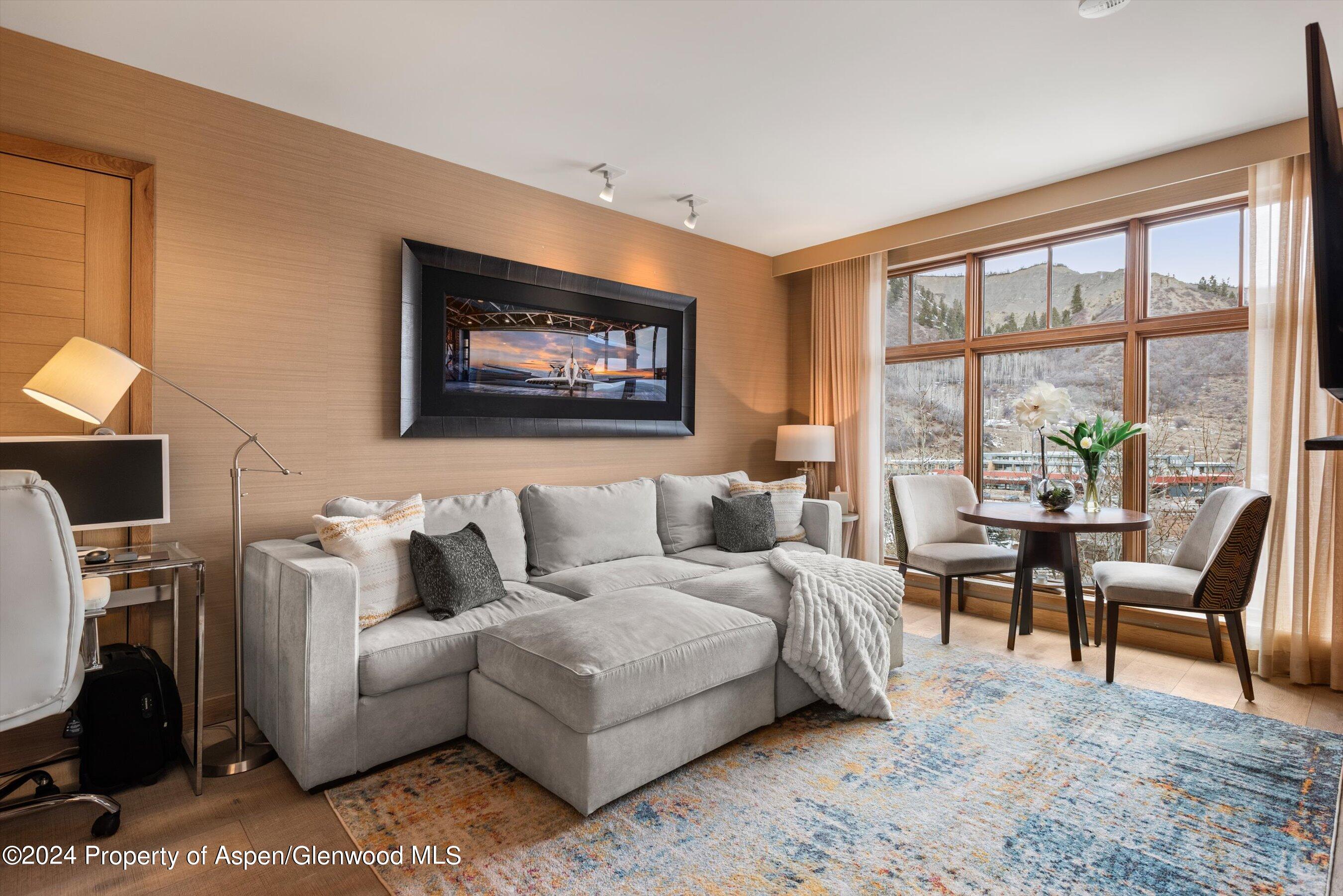 130 Wood Road, Unit 514 Snowmass Village, CO 81615 - Photo 2 of 11 a living room with furniture a large window and a flat screen tv