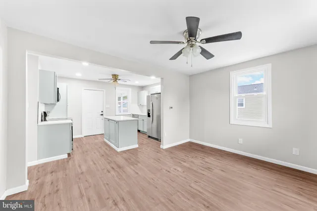 a view of a kitchen and a sink wooden floor windows