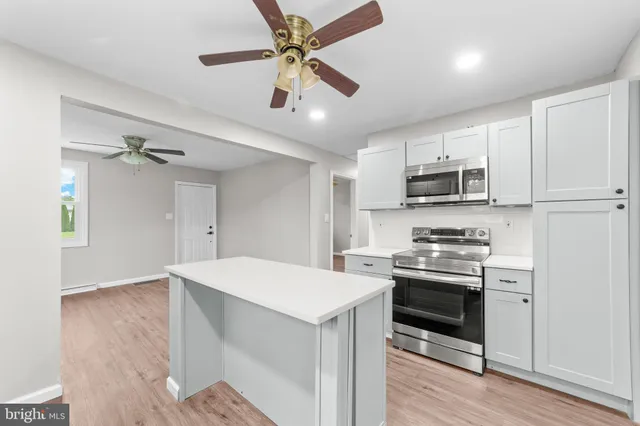 a kitchen with stainless steel appliances a stove sink refrigerator and cabinets