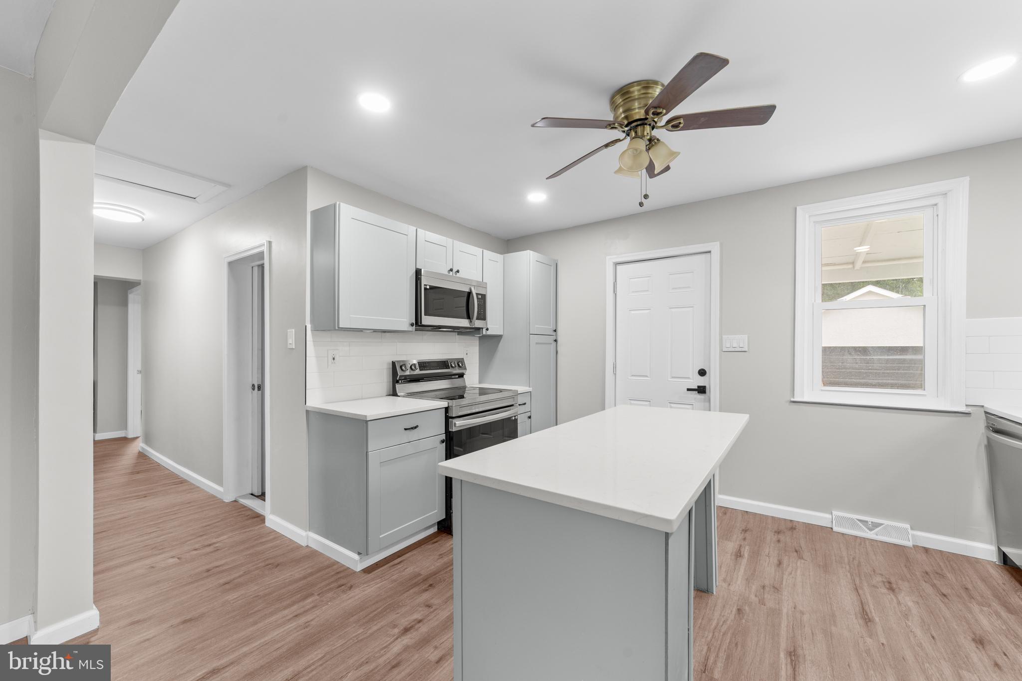 22 Alloway Road Woodstown, NJ 08098 - Photo 9 of 22 a kitchen with stainless steel appliances a white stove top oven a sink dishwasher and a refrigerator with wooden floor