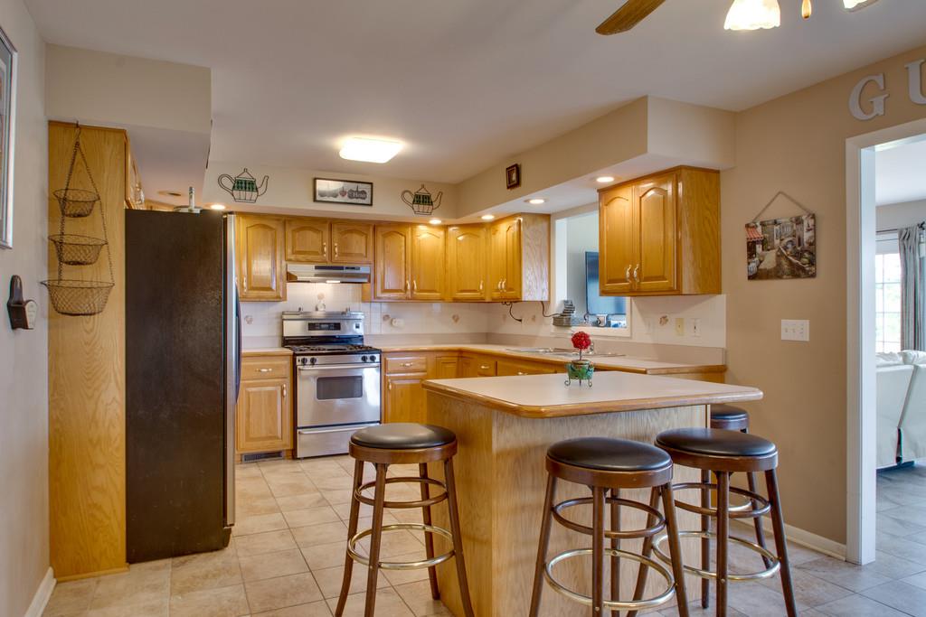 1099 Jump Off Road Bon Aqua, TN 37025 - Photo 3 of 16 a kitchen with stainless steel appliances kitchen island granite countertop a refrigerator and a stove top oven