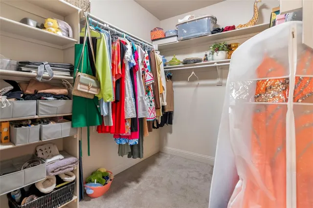 a view of walk in closet with clothes and shoes