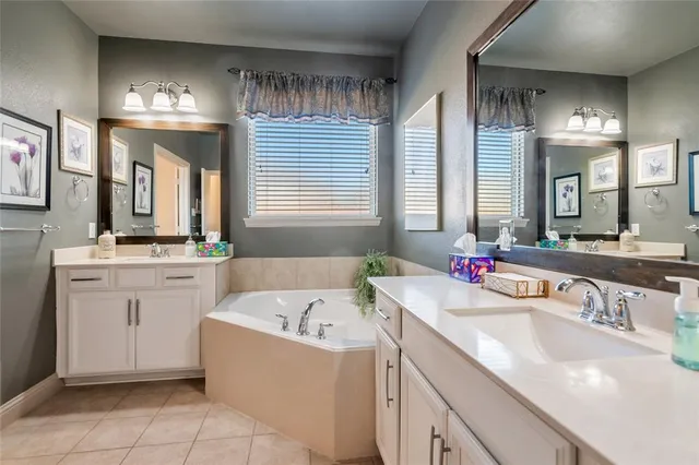 a bathroom with a sink tub vanity and a mirror