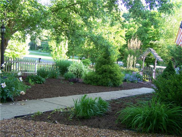 1390 Porter Morris Road Chapmansboro, TN 37035 - Photo 14 of 20 The immediate outdoor space surrounding the front porch is enclosed with a traditional picket fence, fresh mulch & full bloomed shade trees.