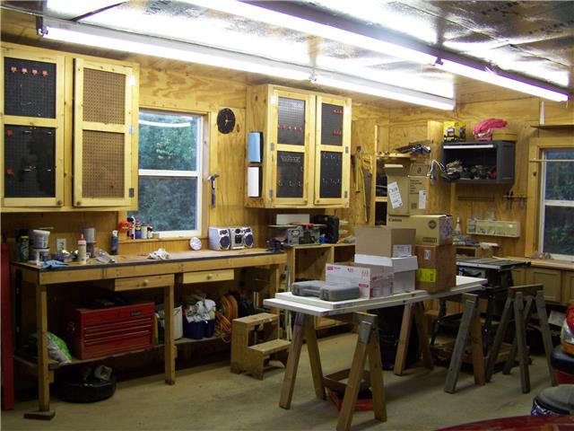 1390 Porter Morris Road Chapmansboro, TN 37035 - Photo 18 of 20 Shop cabinets and work bench inside the garage all remain with the sale. There is an open bannister staircase off to the left leading to the semi finished space above the garage.