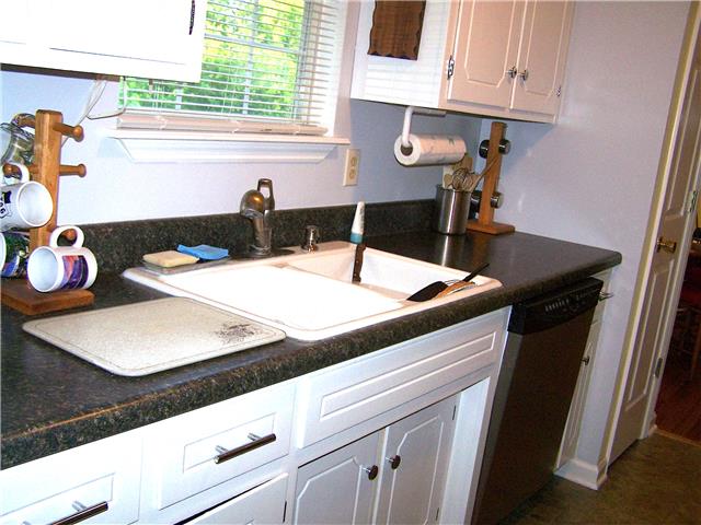 1390 Porter Morris Road Chapmansboro, TN 37035 - Photo 8 of 20 The galley style kitchen has laundry hook ups for washer / dryer spaces at the far end near the side pedestrian door & connects to the eating nook at the opposite end.