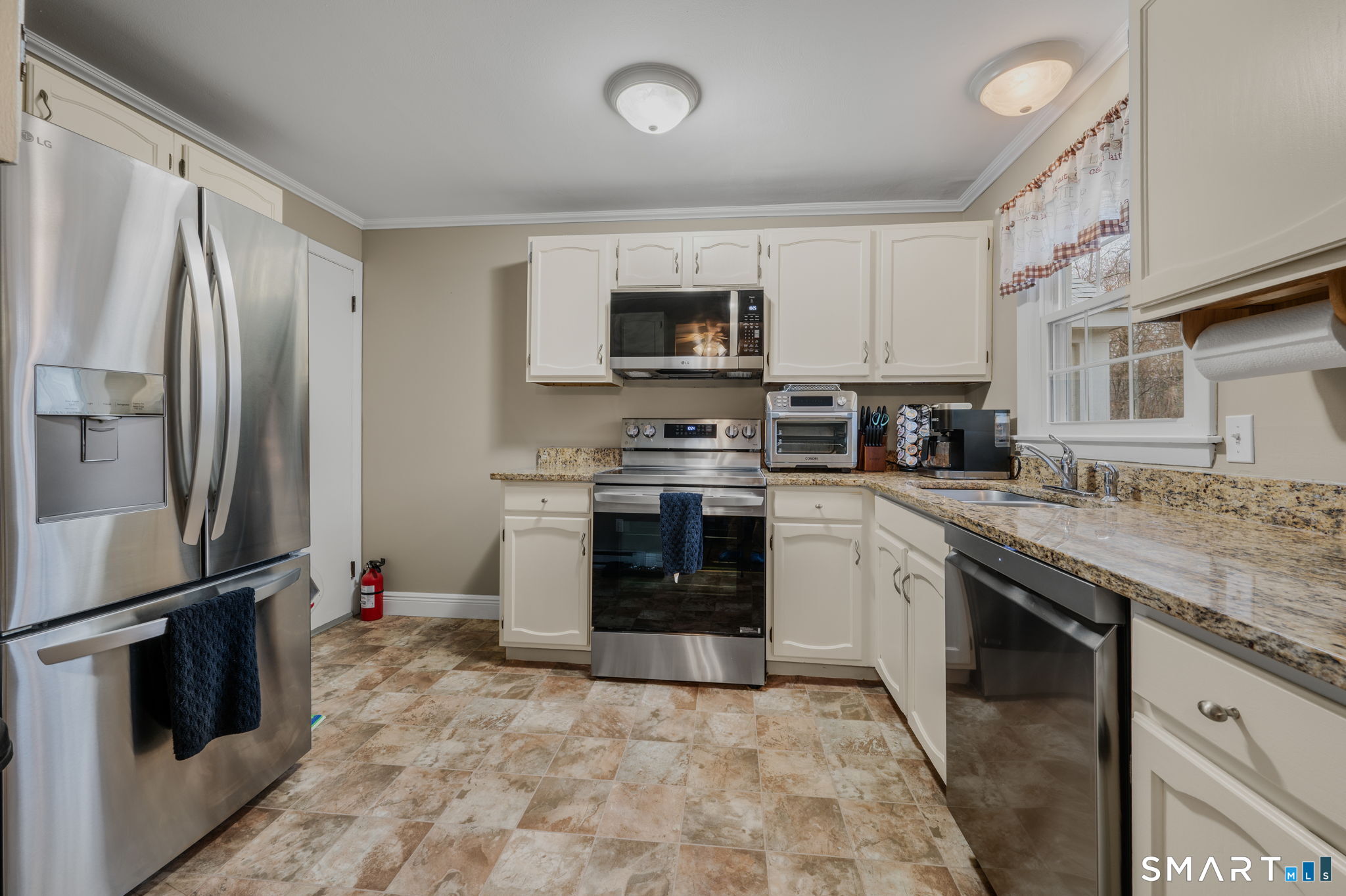 81 East Pattagansett Road, Unit 24 East Lyme, CT 06357 - Photo 14 of 29 a kitchen with stainless steel appliances granite countertop a stove top oven a sink and a refrigerator