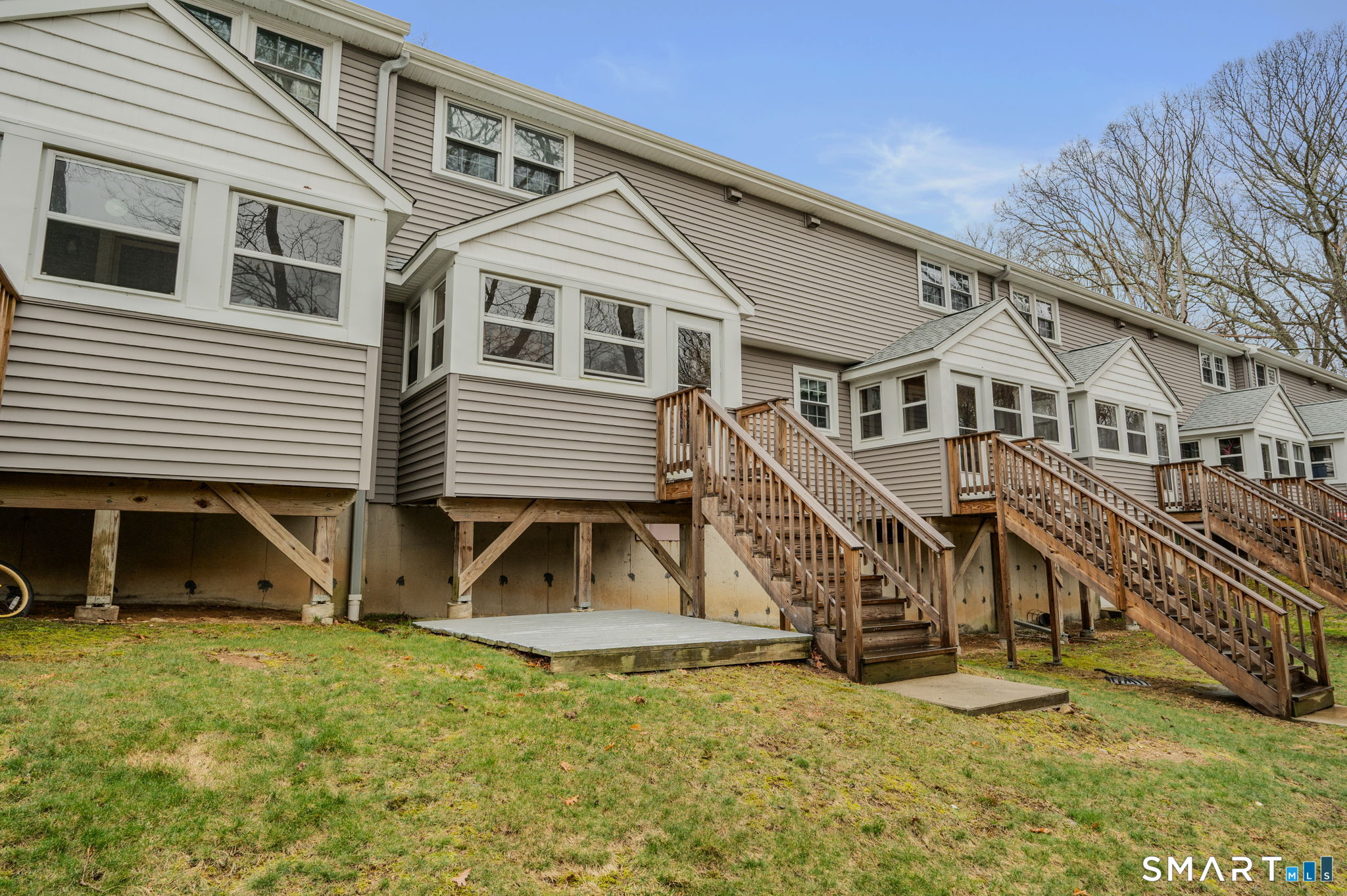 81 East Pattagansett Road, Unit 24 East Lyme, CT 06357 - Photo 6 of 29 a view of a white house with large windows and a small yard