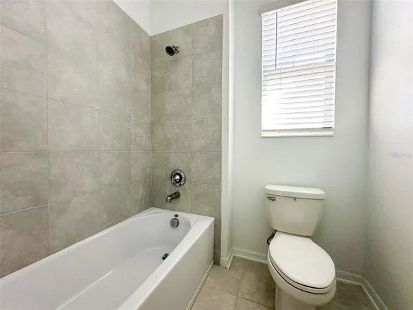 a white toilet sitting next to a bath tub