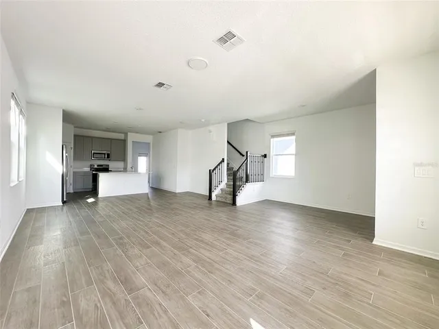 a view of empty room with wooden floor