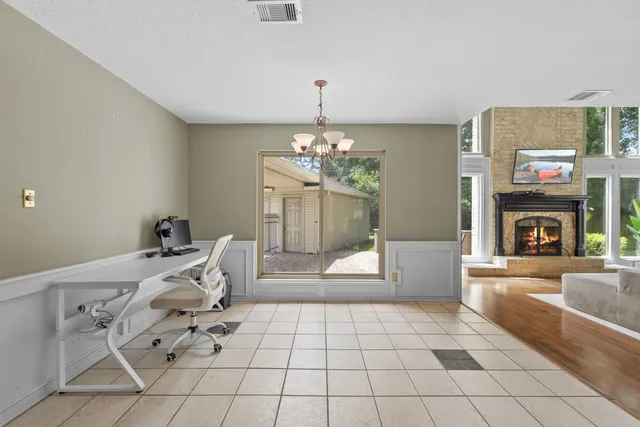 a living room with furniture a fireplace and a chandelier