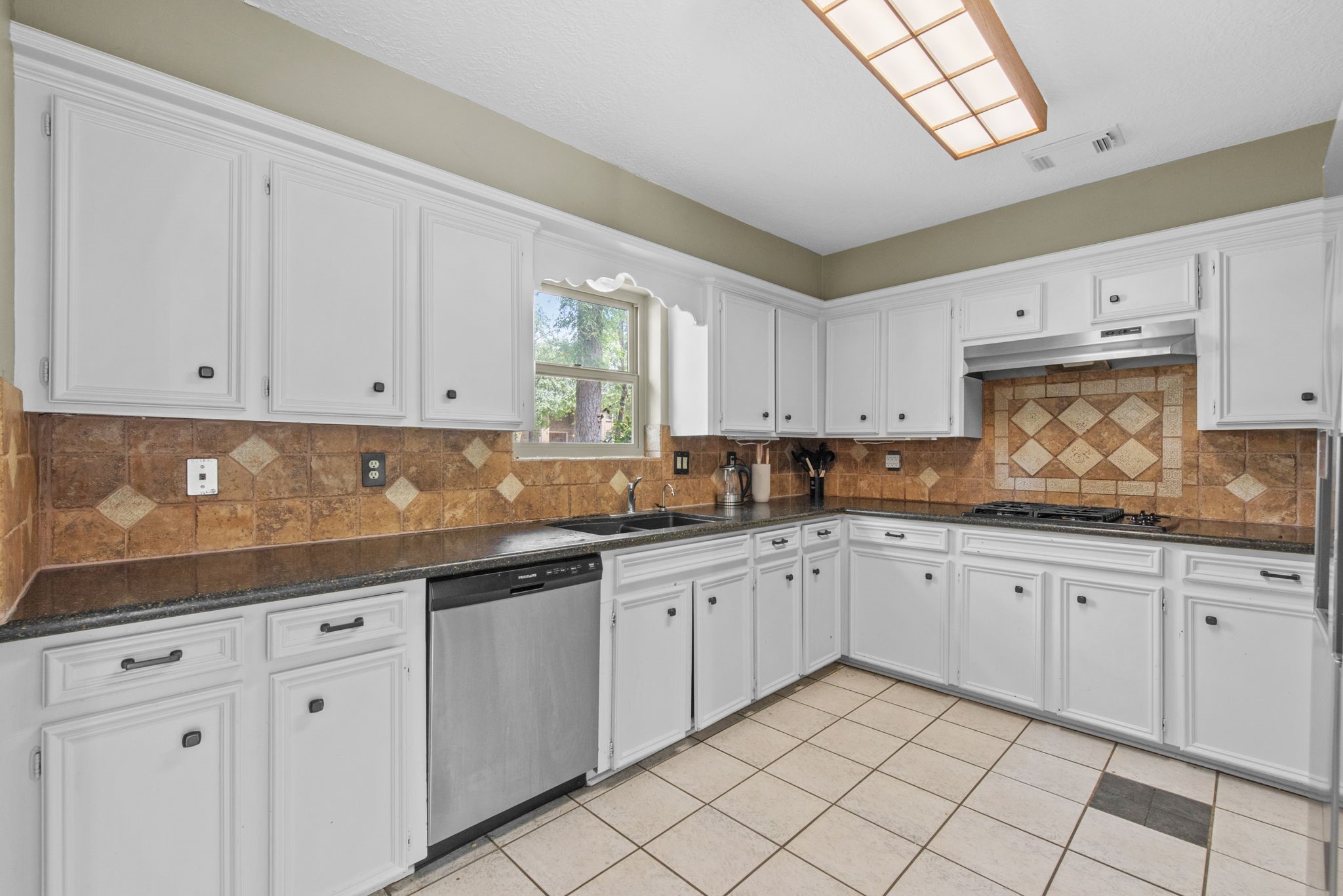 5507 Glenmere Lane Spring, TX 77379 - Photo 16 of 37 a kitchen with granite countertop white cabinets white appliances and sink