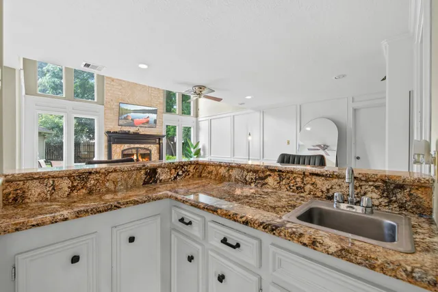 a kitchen with granite countertop a sink and cabinets