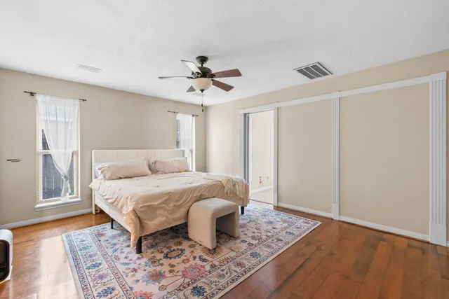a bedroom with a bed and wooden floor