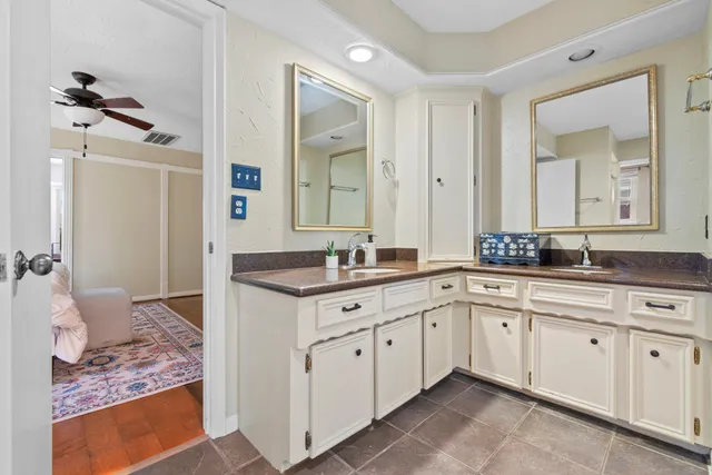 a spacious bathroom with a granite countertop sink and a mirror