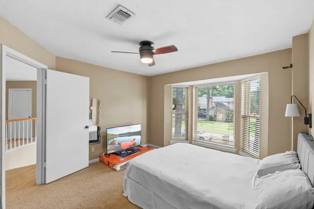 a bedroom with a bed and large window