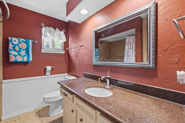 a bathroom with a toilet a sink and mirror