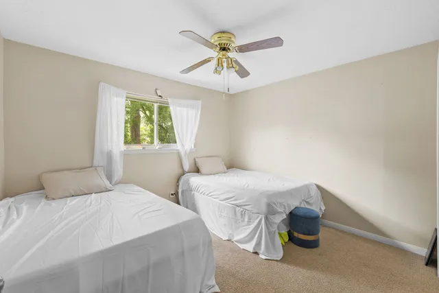 a bedroom with two beds and chandelier